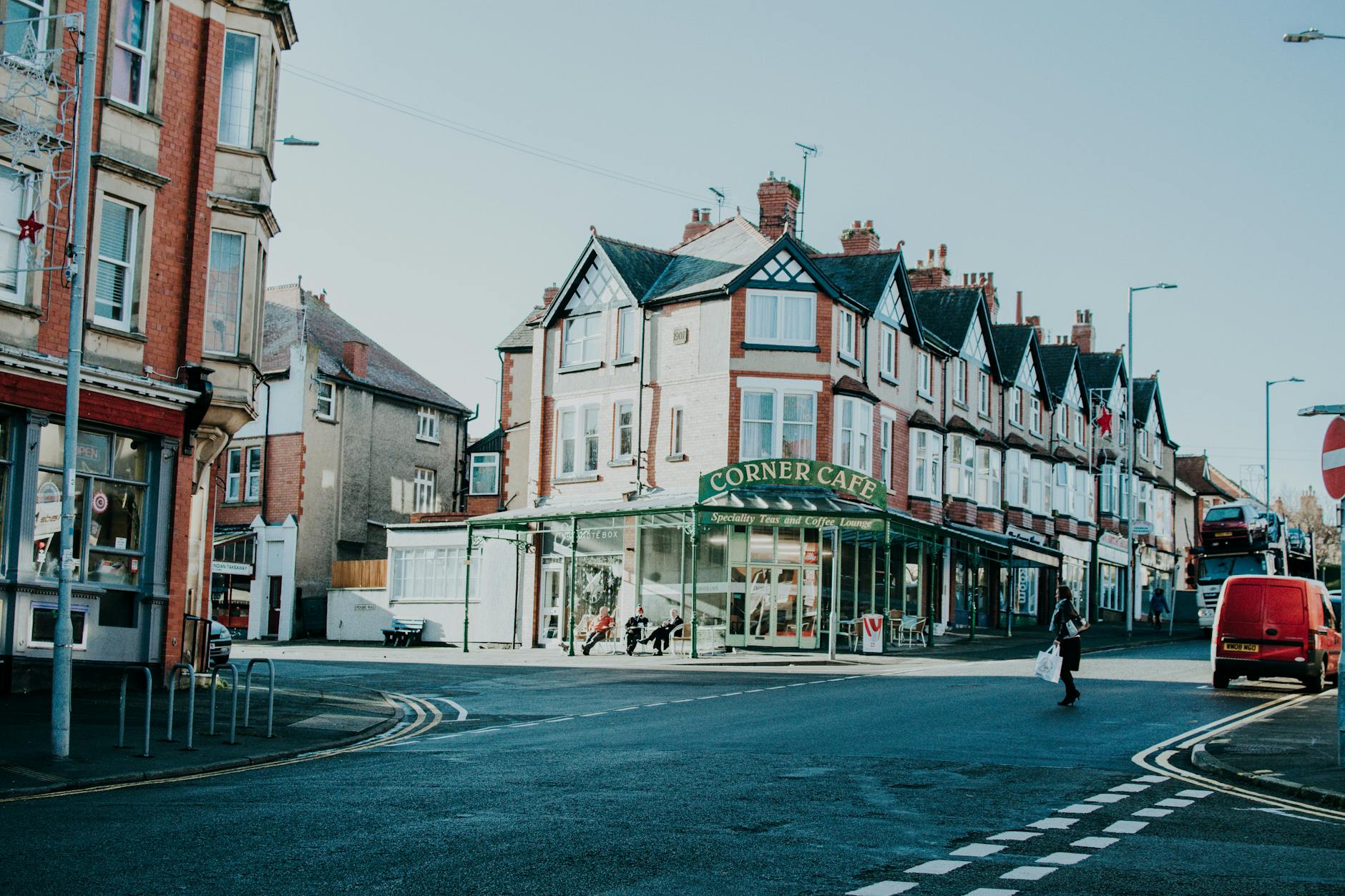 Charming street view with a prominent corner café, highlighting urban architecture and daily life.