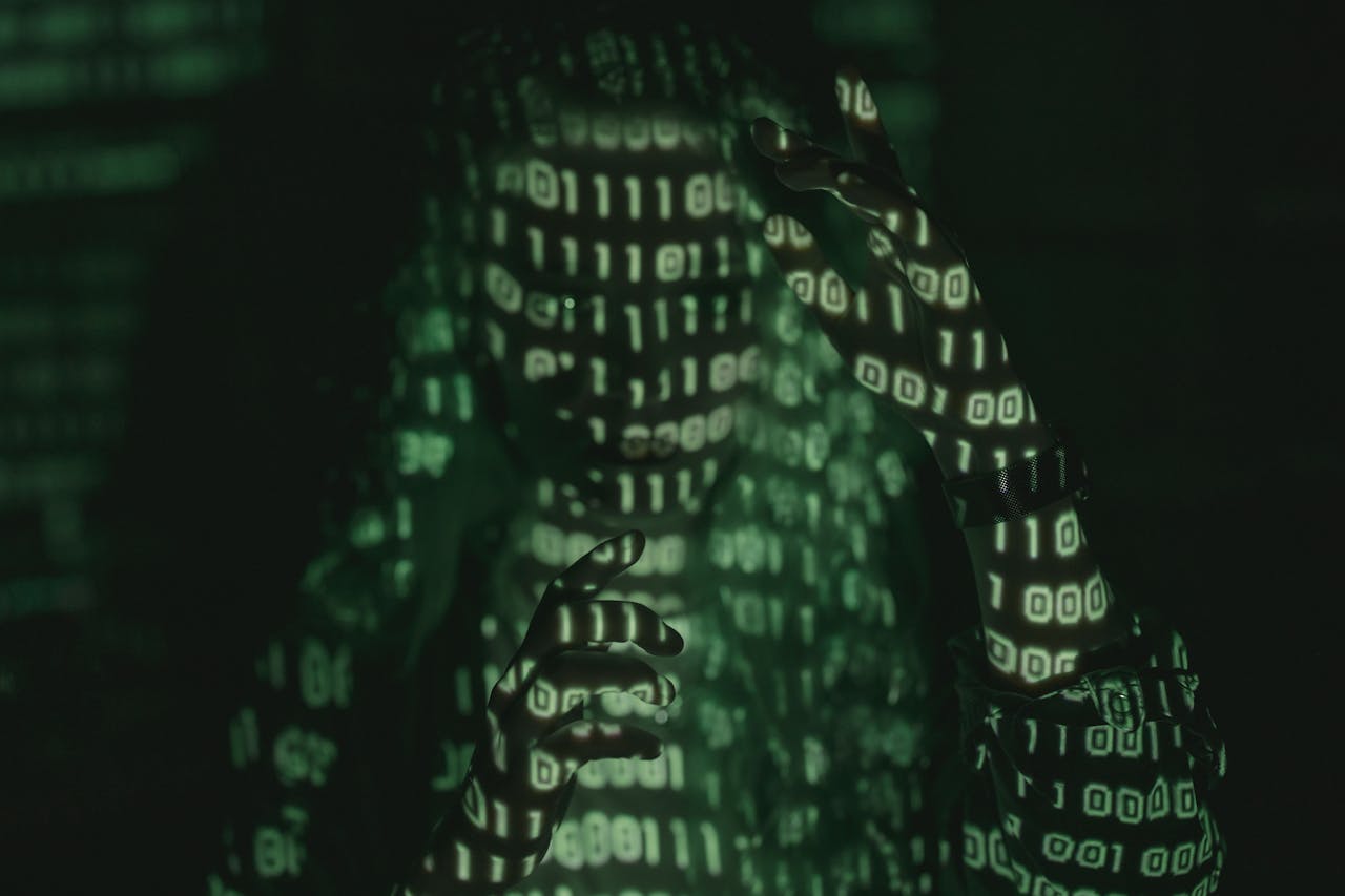 contact-header An unrecognizable person with binary code projected, symbolizing cybersecurity and digital coding.