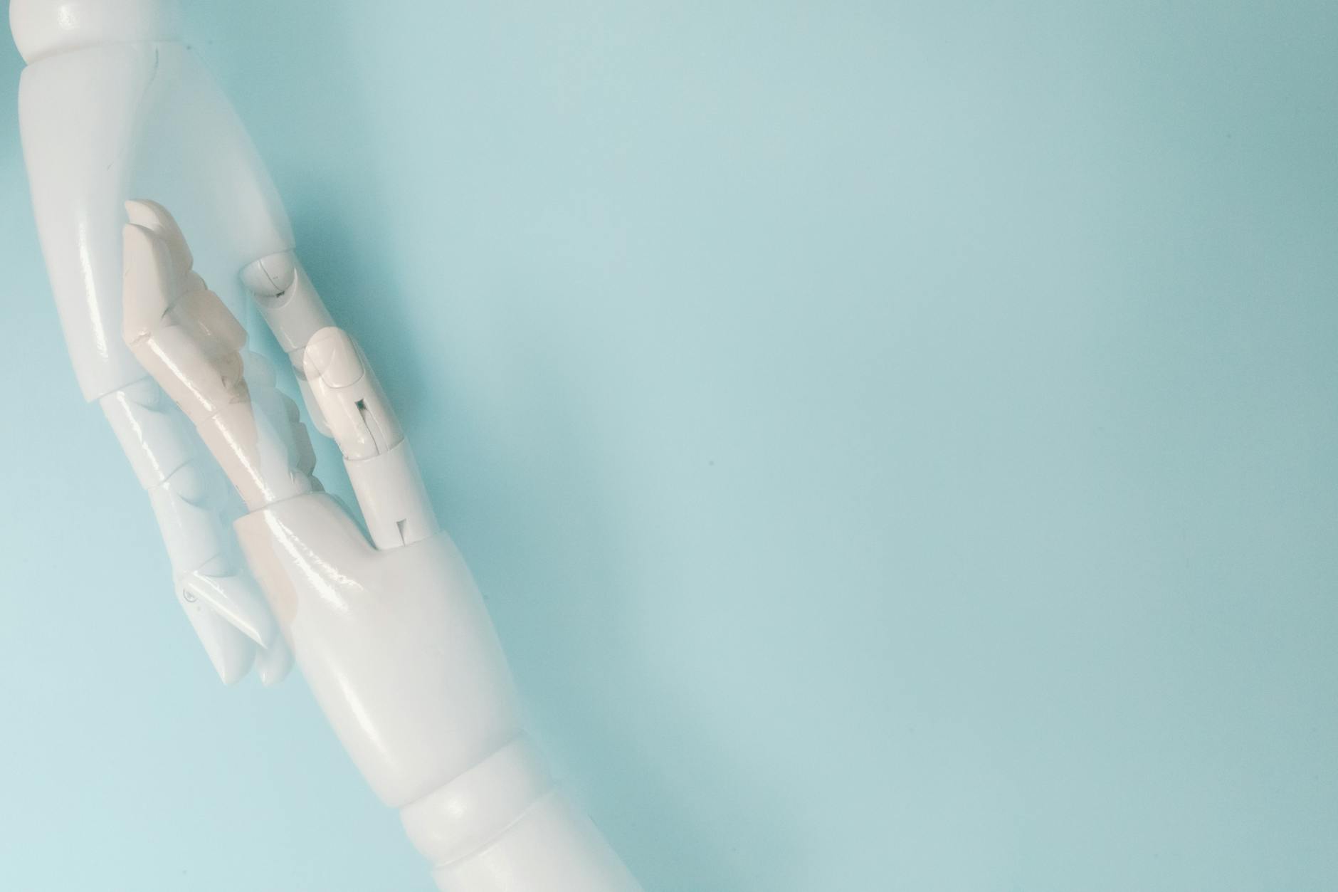 Two robotic hands on a blue background representing technology and innovation.